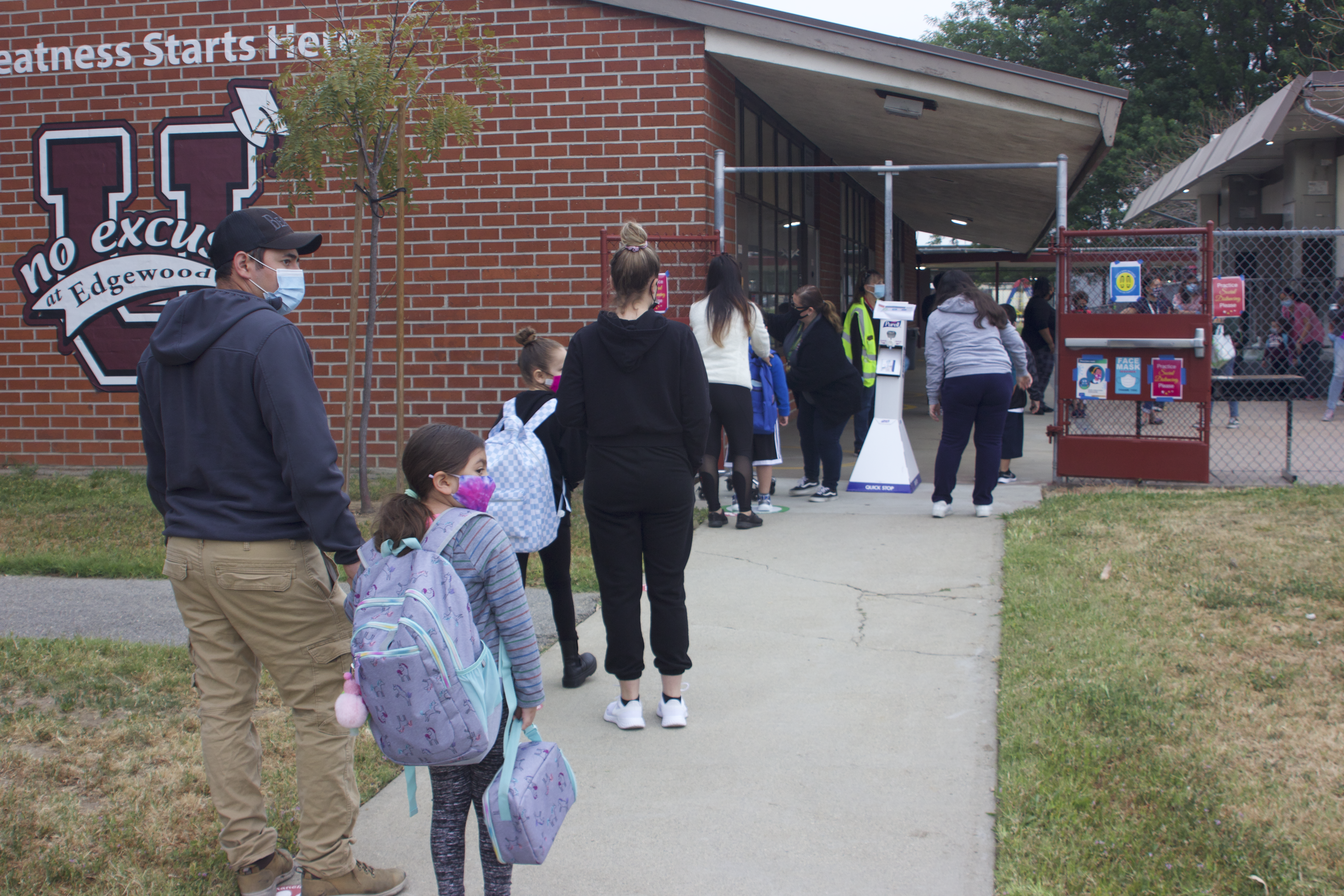 Parents and students wait to be screened before entering campus at Edgewood Academy